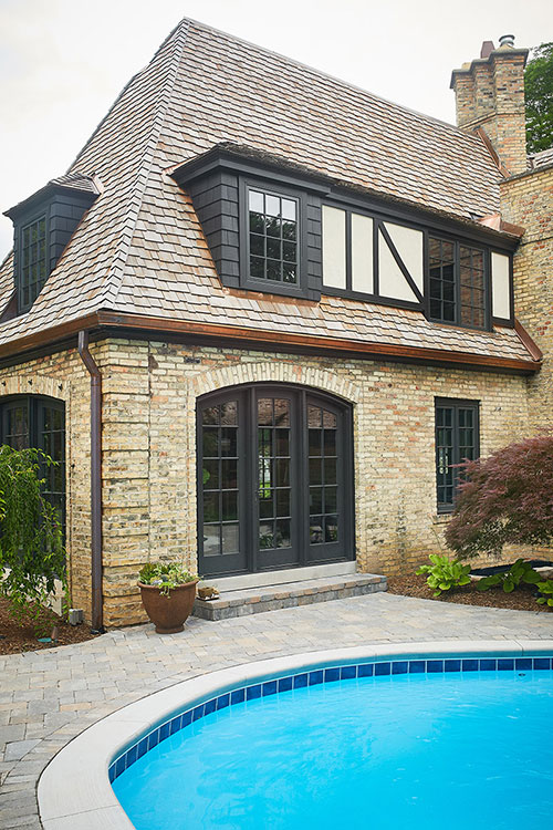 A view from the backyard of the roofing work Buist provided for a Tudor style residential home in East Grand Rapids, MI