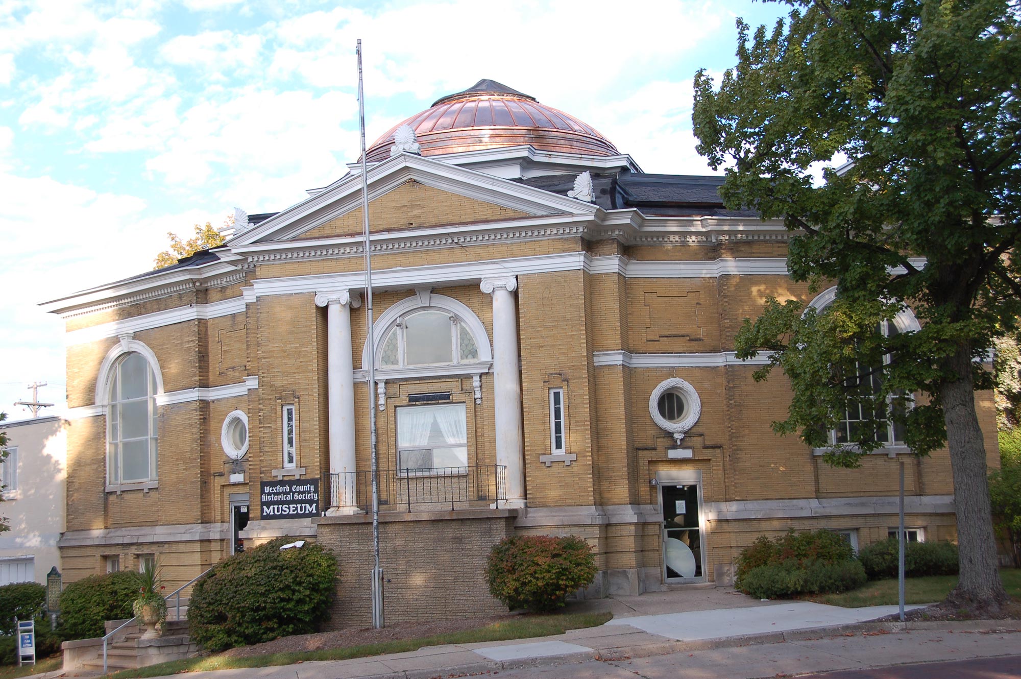 A view of the entire Wexford County Historical Society Carnegie Library Museum featuring the copper dome.