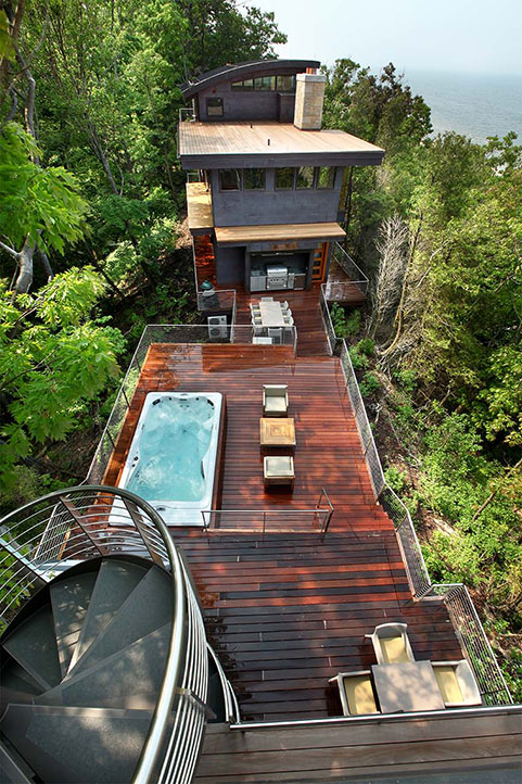 An aerial view of the Dunes residential sheet metal construction project shows both sides of the home connected by a modern wooden deck complete with a in-ground hot tub.